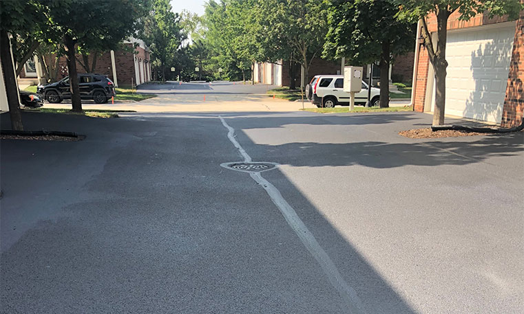 asphalt driveway in front of townhomes