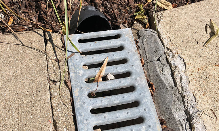 clogged drain on damaged concrete