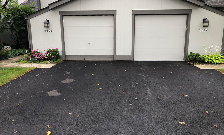 home garage and driveway after asphalt replacement