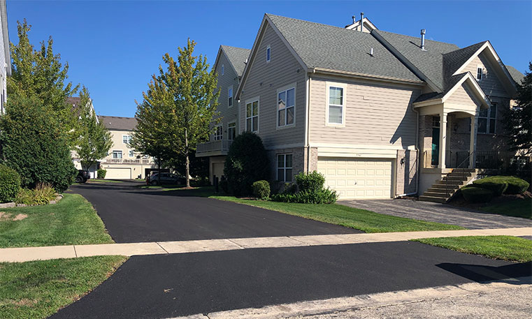 finished asphalt street in front of townhome