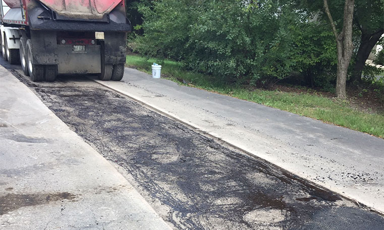 asphalt patching equipment working on damaged concrete