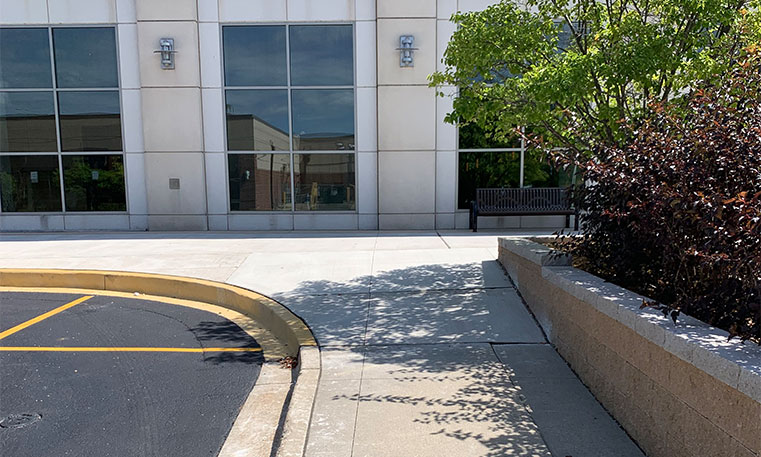 finished concrete curb and parking lot markings in front of hotel