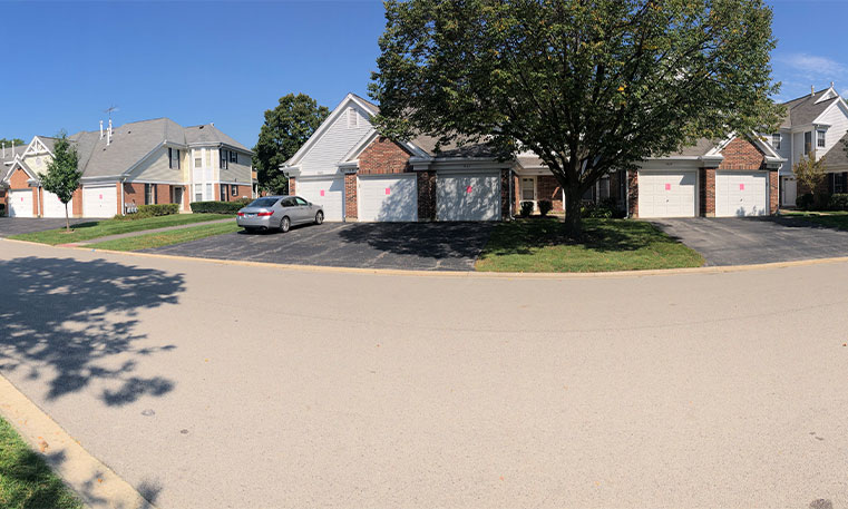 street view of home with sealcoated driveway